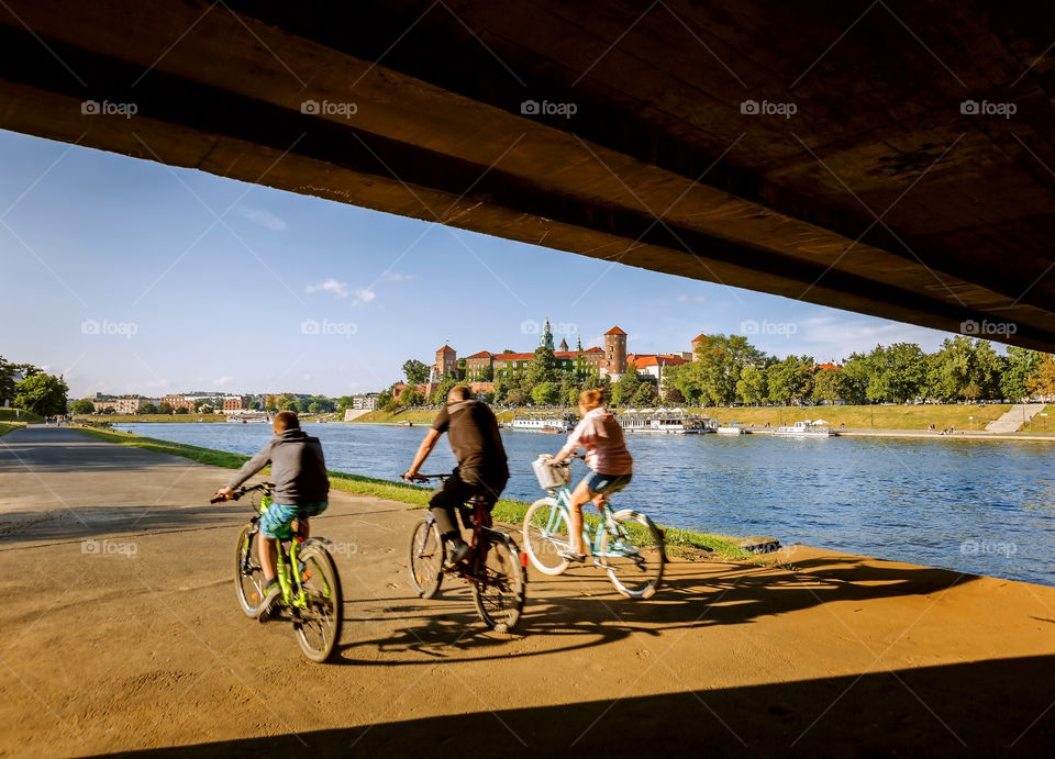 Biking by Vistula river with a view of Wawel castle in Krakow