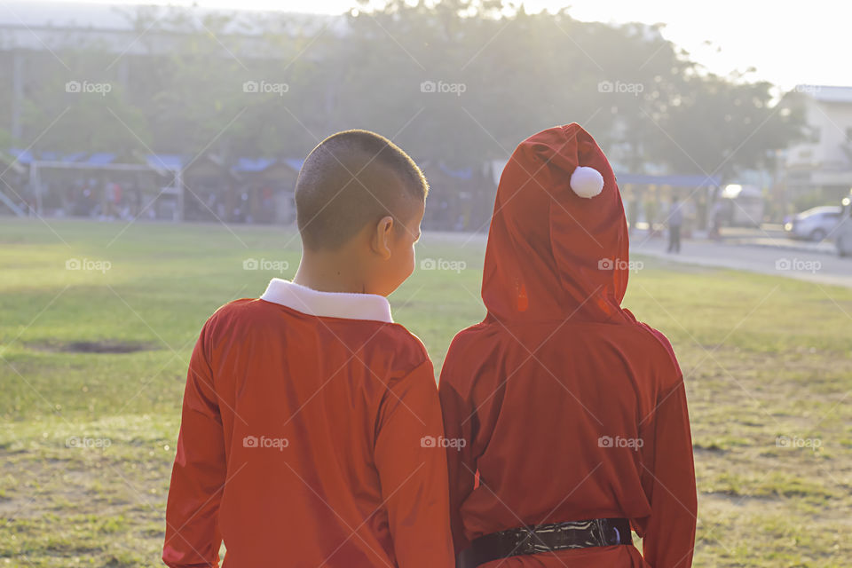 Asia boy wearing a red Christmas Background on the school lawn.