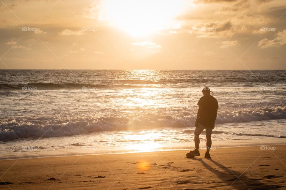 A man enjoying the sunset on the beach 