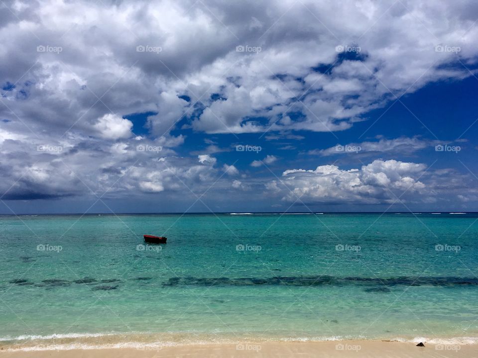 Little Red Boat Floating in Mauritius as the Clouds Roll In on a Sunny Day