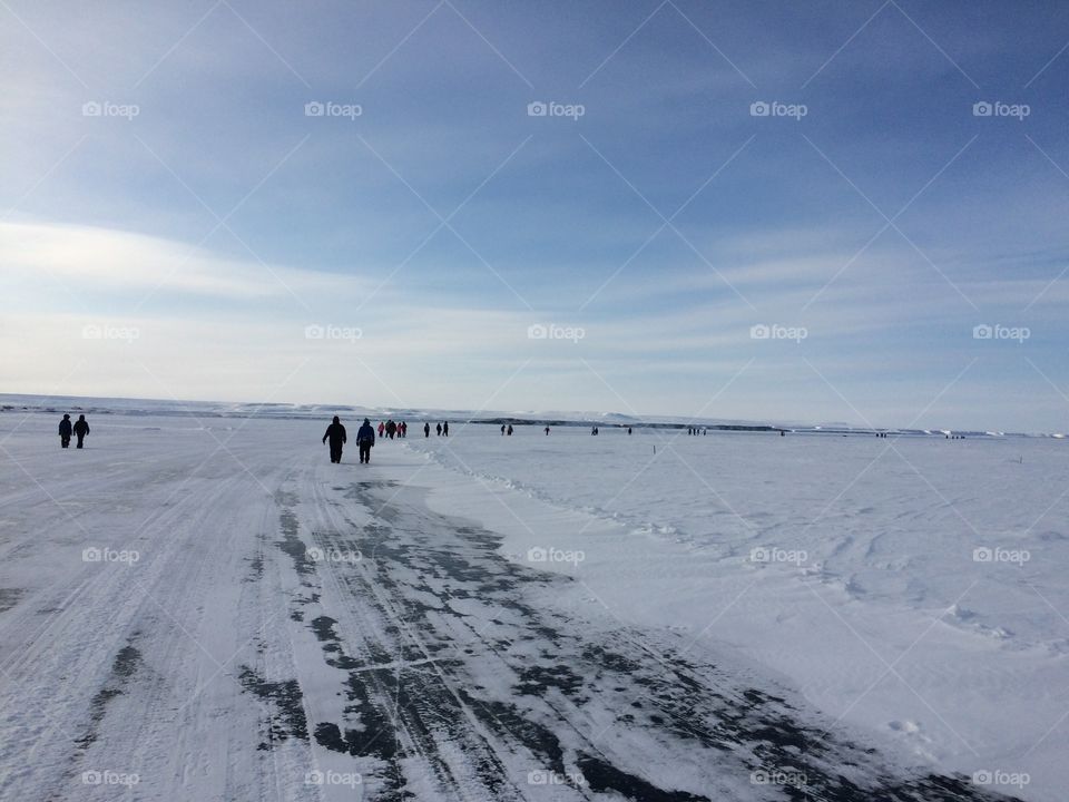 People walking down an ice road on the Arctic Ocean 