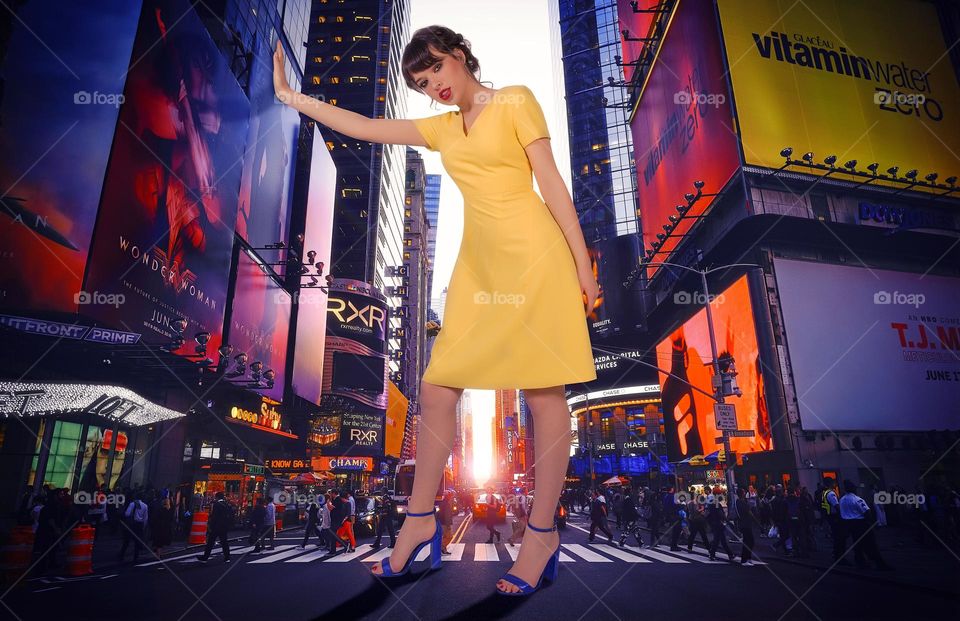 Giant woman with yellow dress in the middle of a New York boulevard supporting herself on a skyscraper billboard 