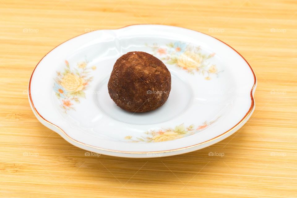 Plate with panellet on a wooden surface. Panellets are traditional sweets for All Saints' Day in Catalonia, the Balearic Islands, Levante and Aragon.