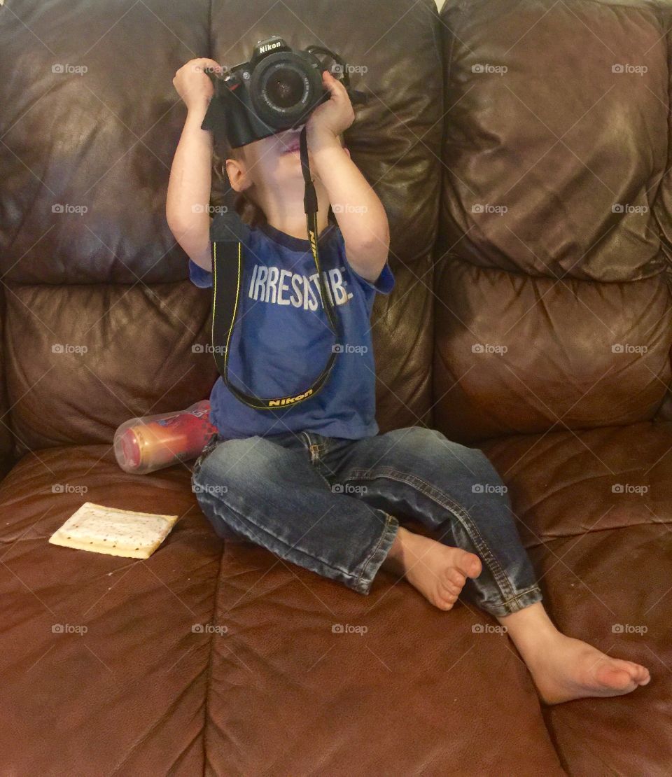 Grandson trying to take pictures of me but camera Nikon D5200 is to big for him.
