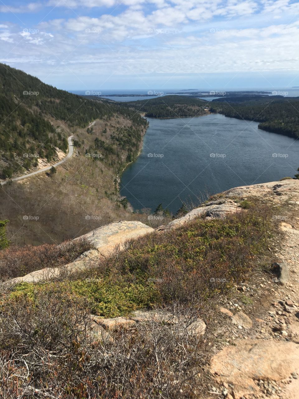 Overlooking the Acadian trails and Eagle lake. Bits of islands and the sea are visible by the looming side of the mountain.