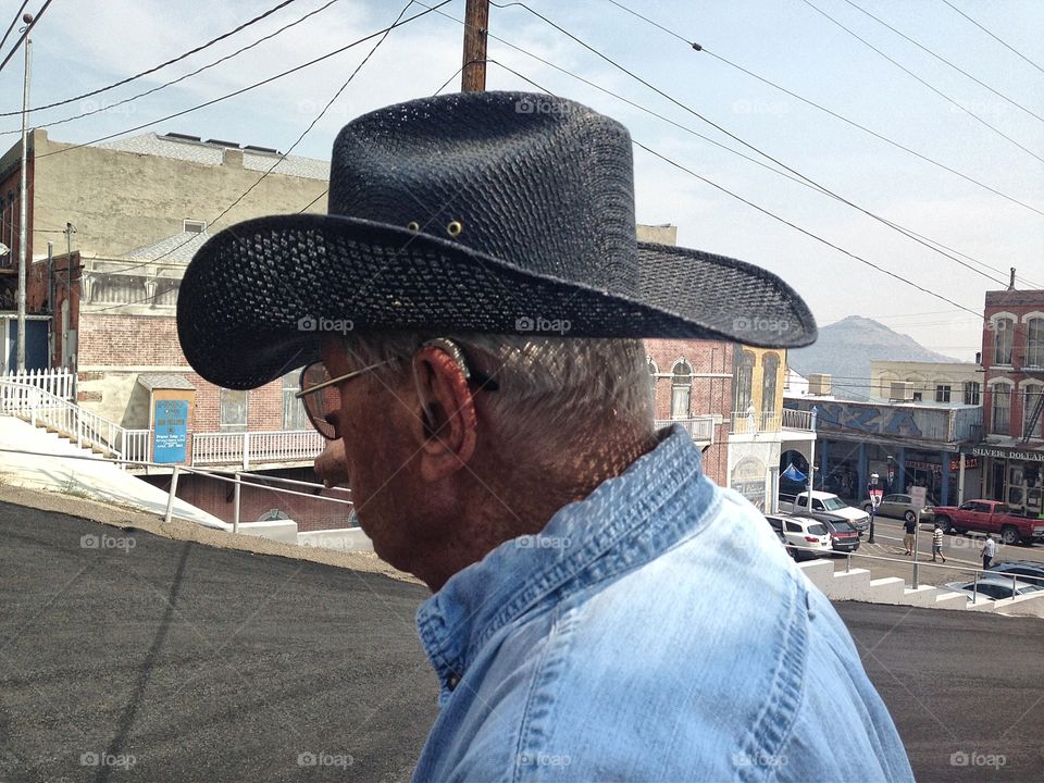 Elderly senior cowboy in black hat and denim shirt in town for the day