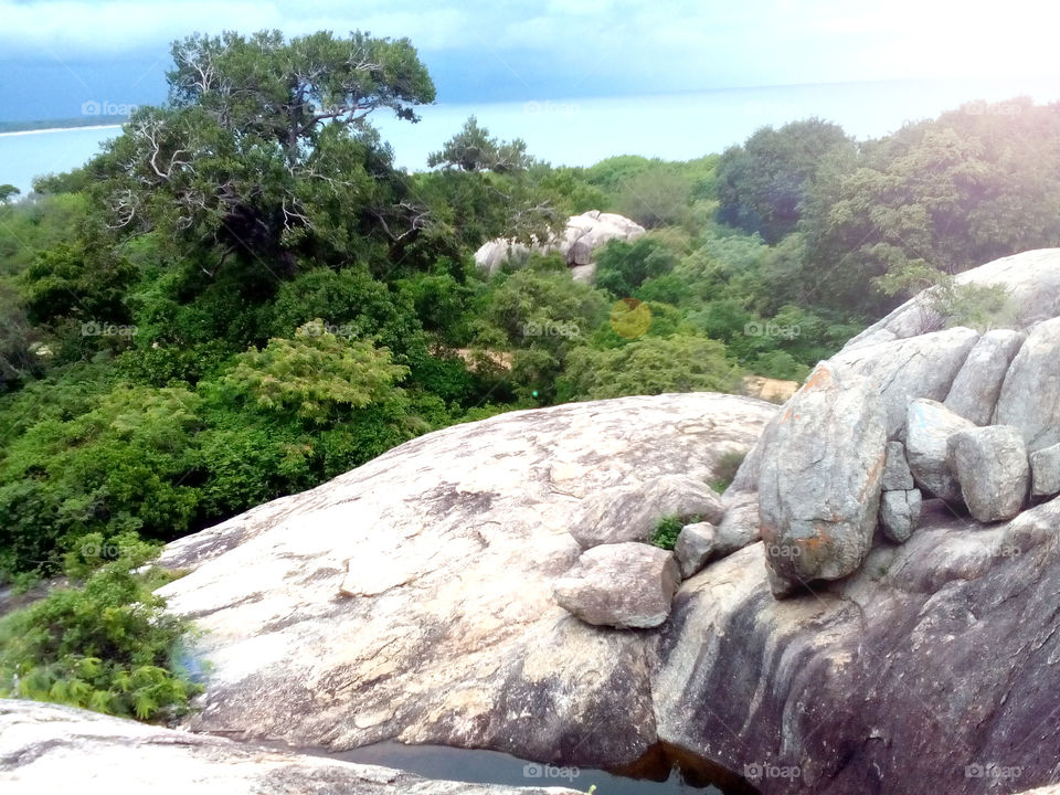 sunny day view of blue sea and blue sky from top of rock mountain. and beautyful sight of greeny trees