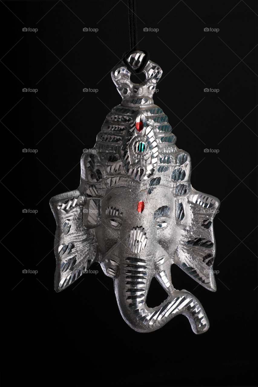 Hindu lord Ganesha silver idol statue. Religious icon for prayer.