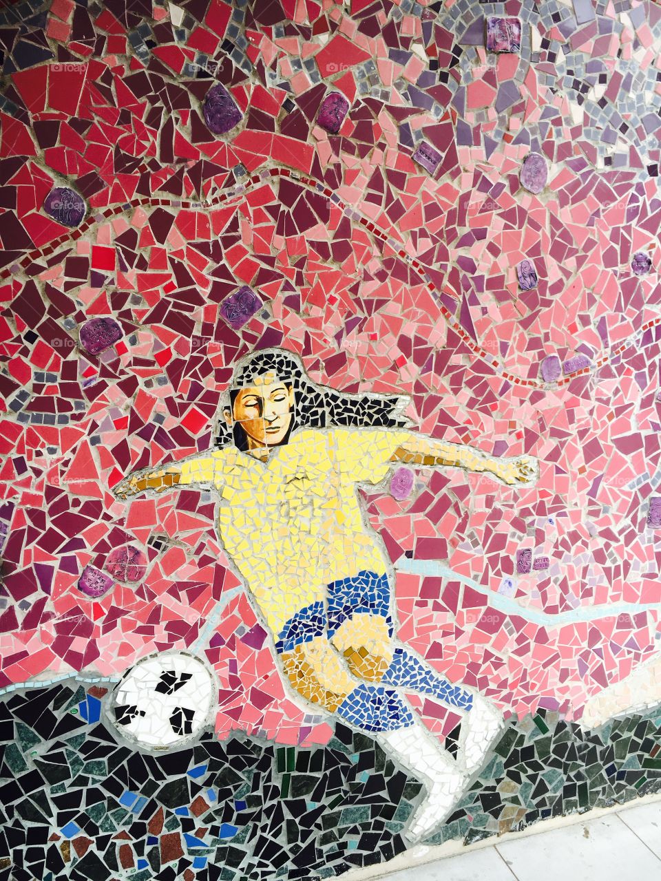 Girl in a yellow shirt playing football
