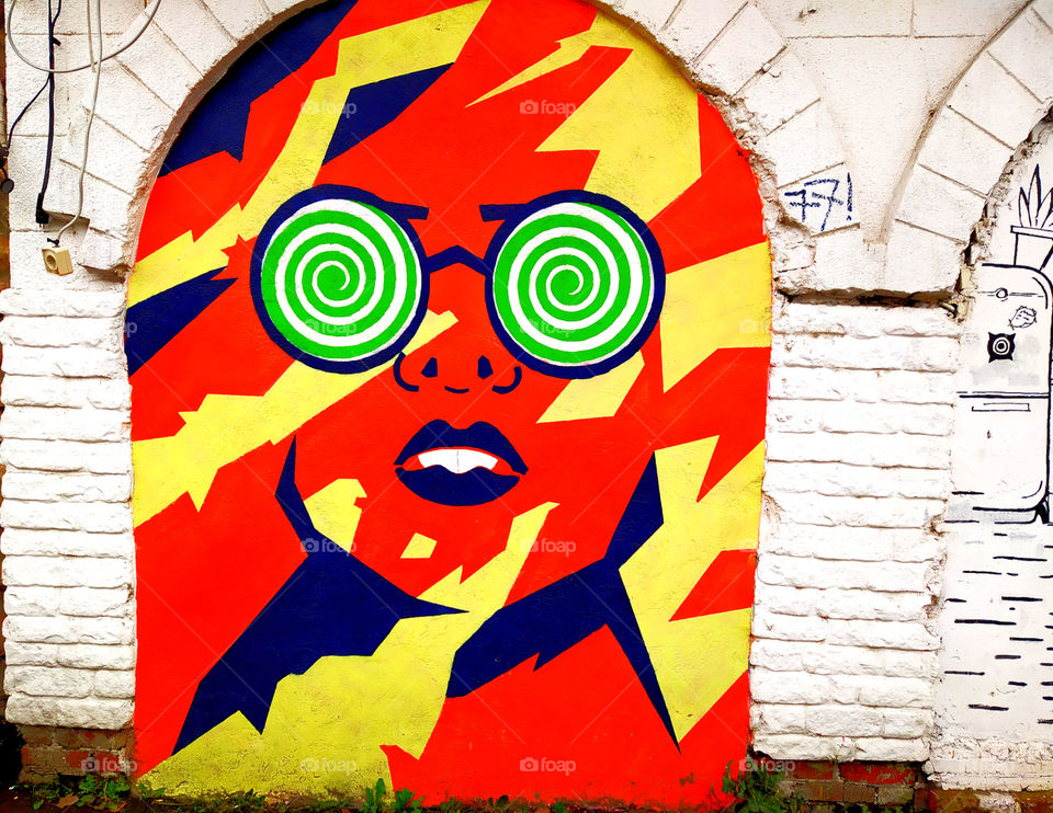 Graffiti.  Multicolored face of a girl with glasses
