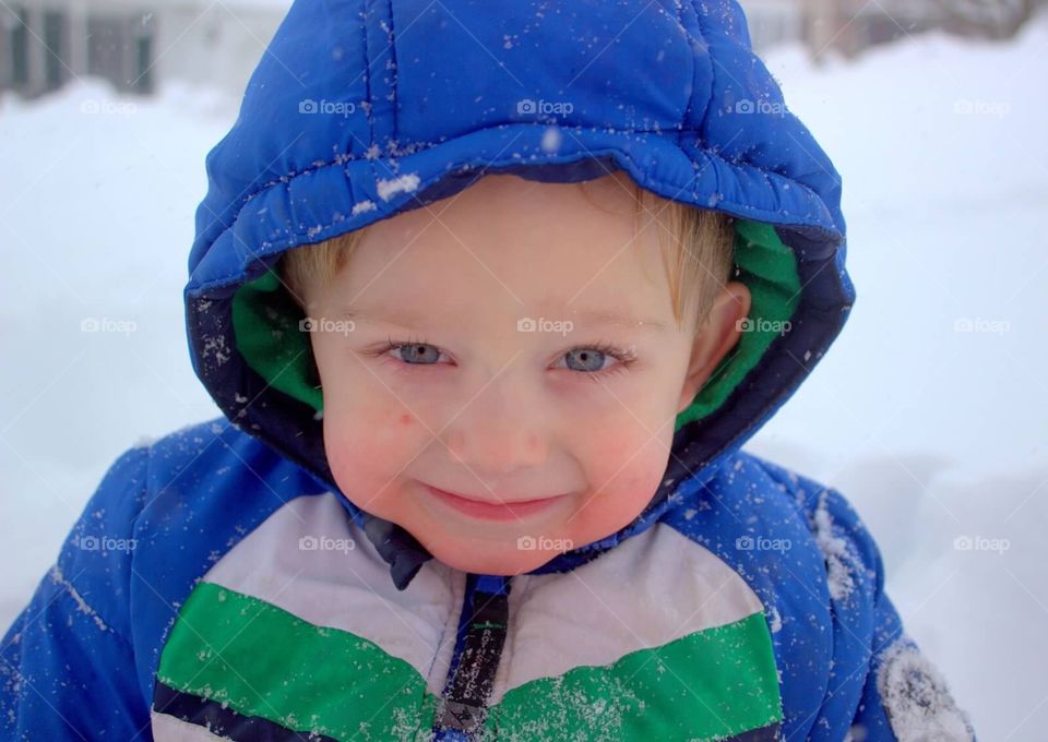 Toddler boy, with bright blue eyes, outside in the snow. 