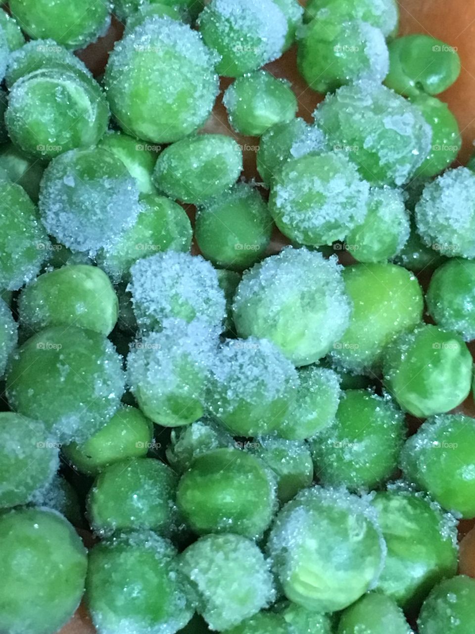 Close up view of frozen green peas with ice crystals on them 