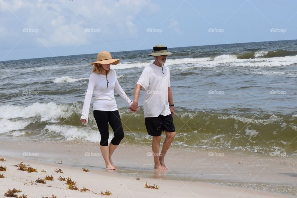 Couple walking along the beach holding hands 