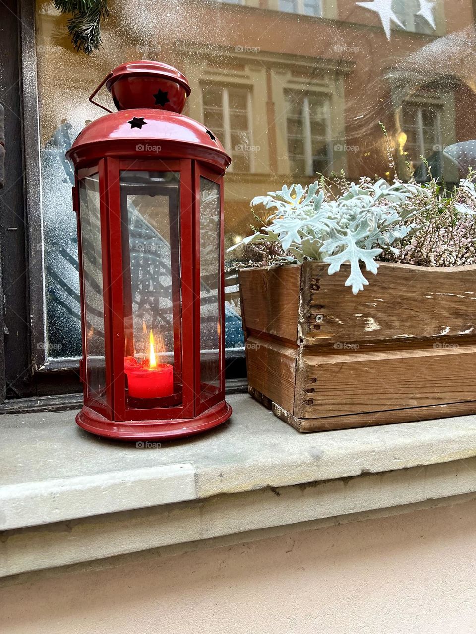 New Year's composition on the windowsill, street lamp and flowerpot with flowers on the streets of Warsaw