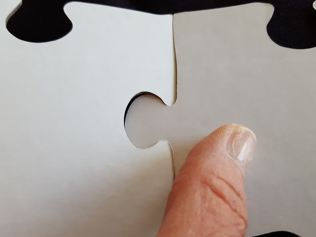 Extreme close-up of human finger with puzzle