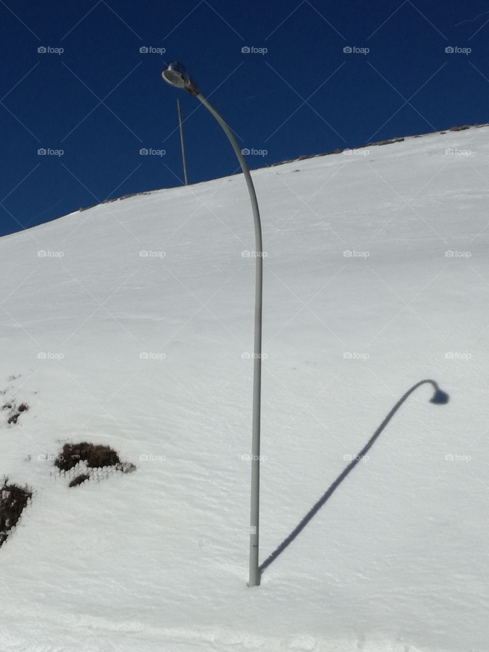 A lamppost and its shadow on the withe A lamppost and its shadow on the white snow