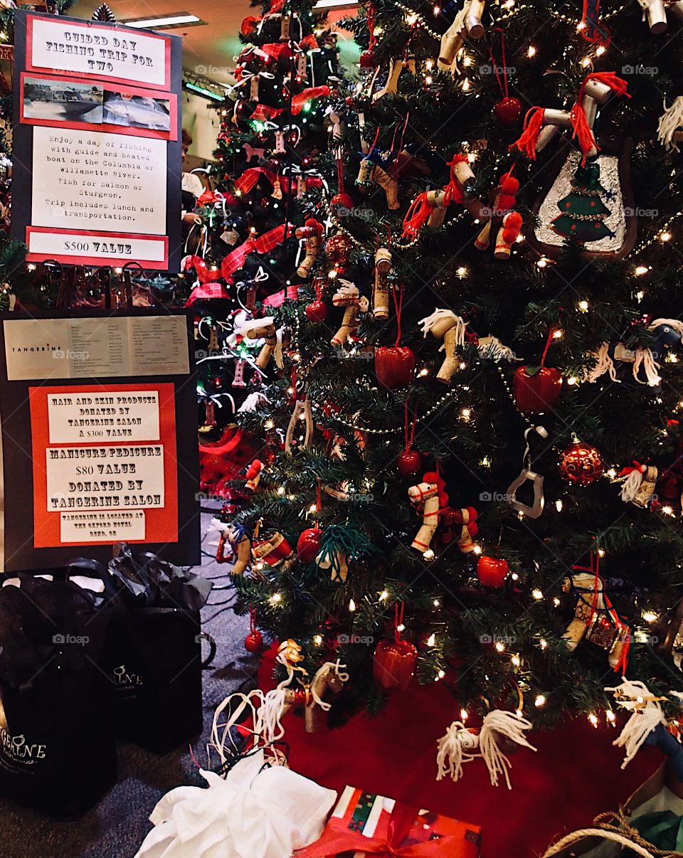 A beautifully decorated Christmas tree on display for a fundraising event. 