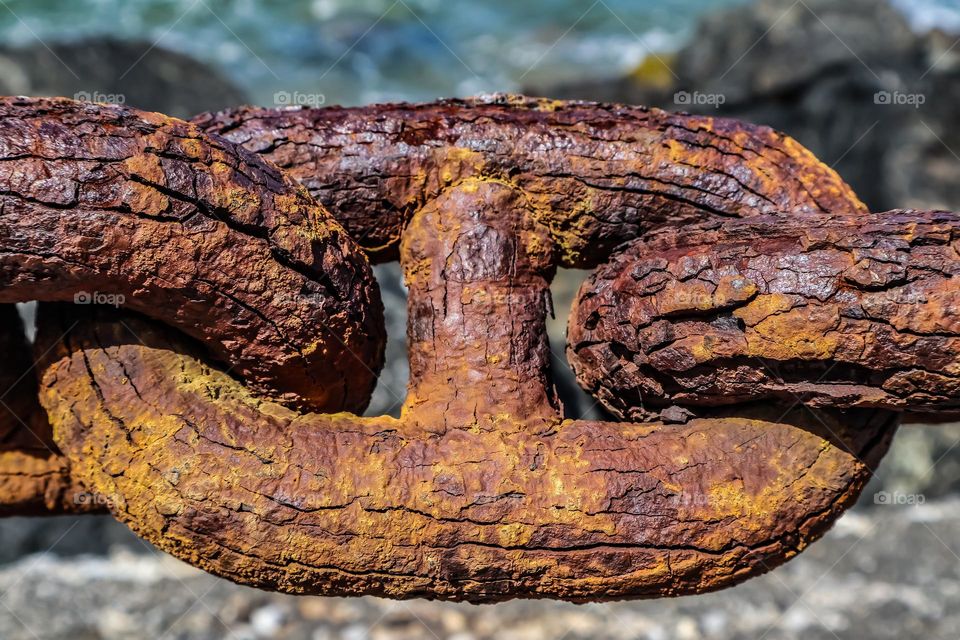 Closeup detail of a Rusty iron chain link fence structure along the coast of the San Francisco Bay by Fort Point at the base of the Golden Gate Bridge 