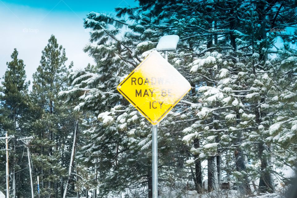 Road may be icy sign covered in ice and snow