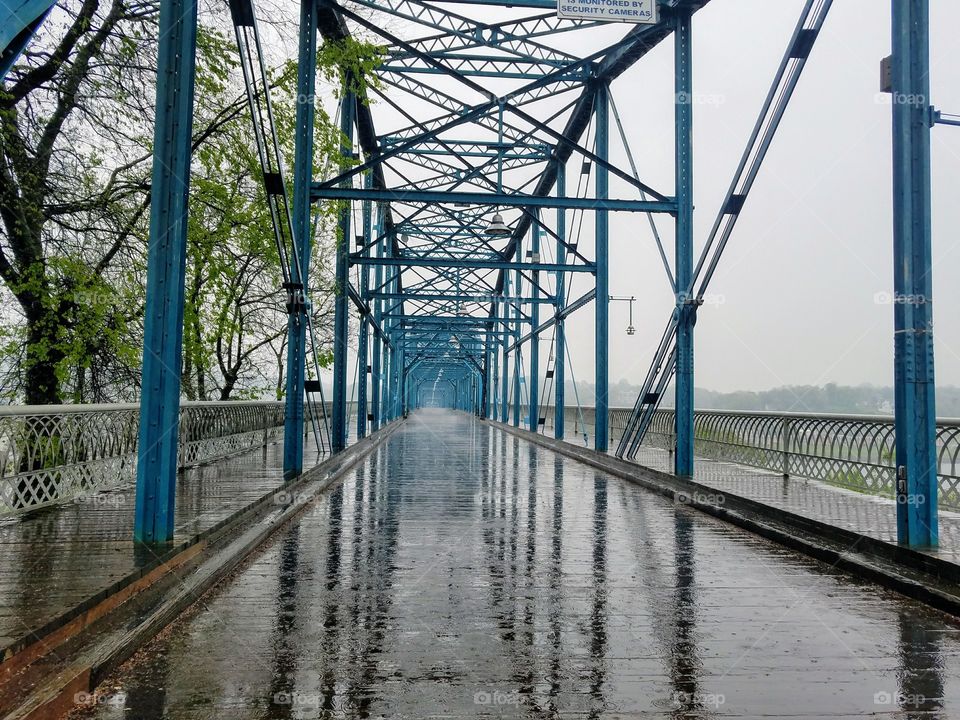 Rainy day strolls on a captivating bridge.