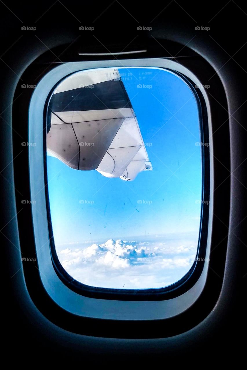 Clumping clouds below the plane in eye level view