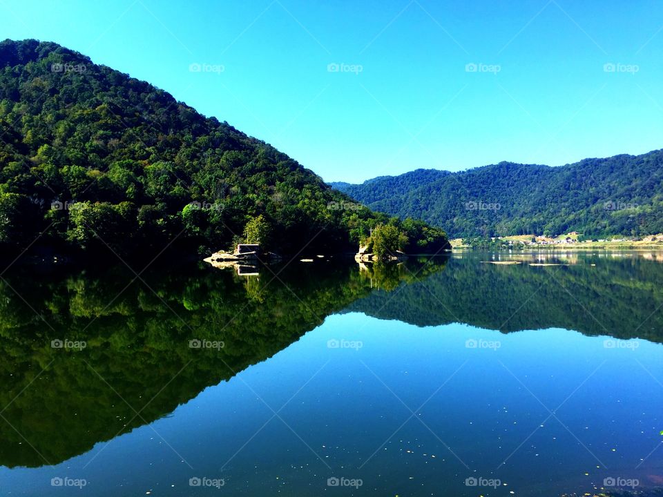 Clear sky and mountain reflecting on river