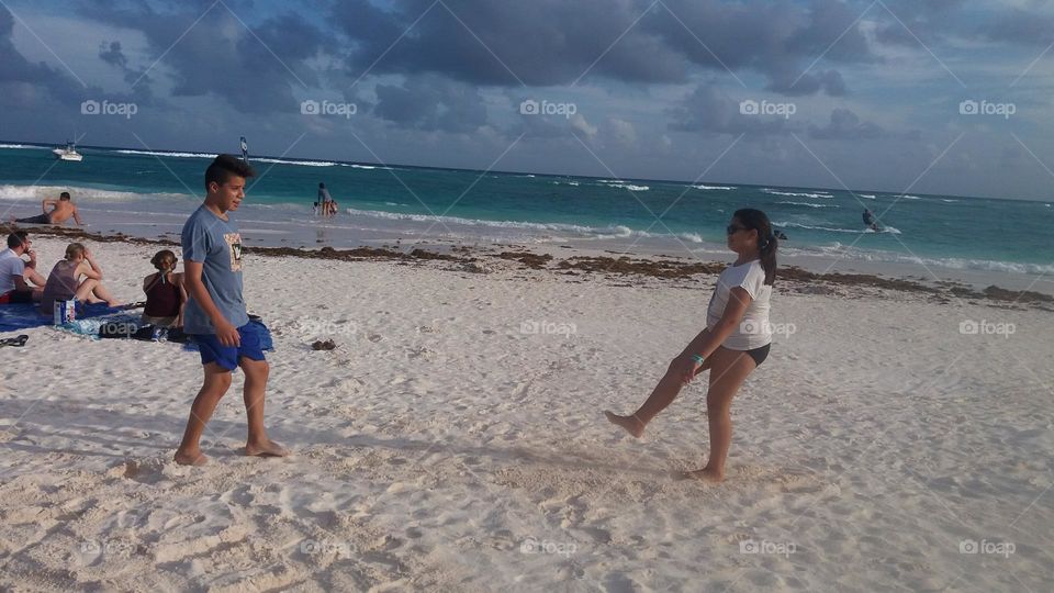 los niños juegan en la playa una tarde de verano