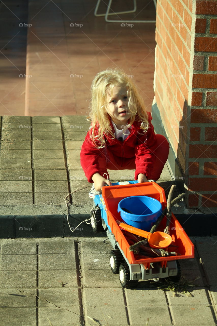 little girl playing with a wheelbarrow