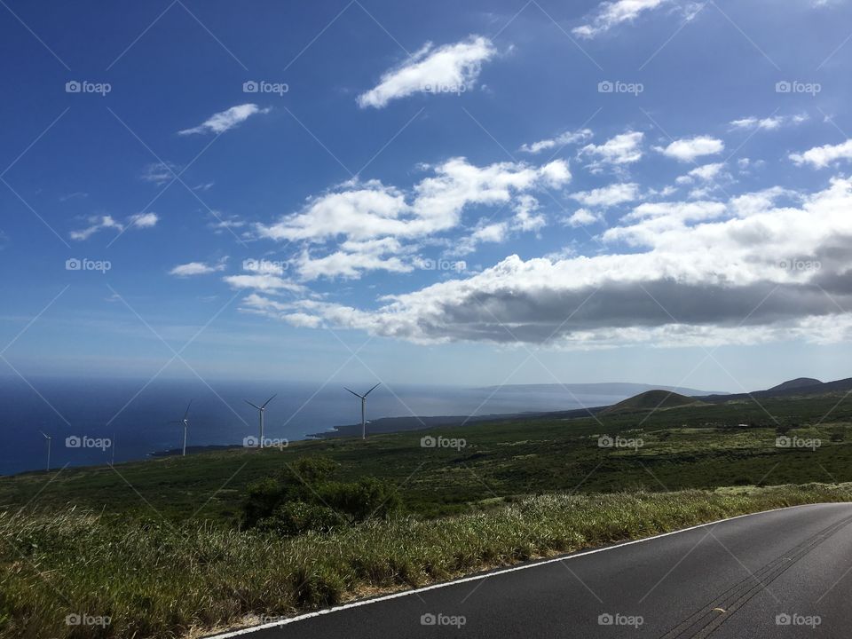 A clear view of the distant wind mills along the island coast of Hawaii on the road to Hana on a beautiful, sunny day. 