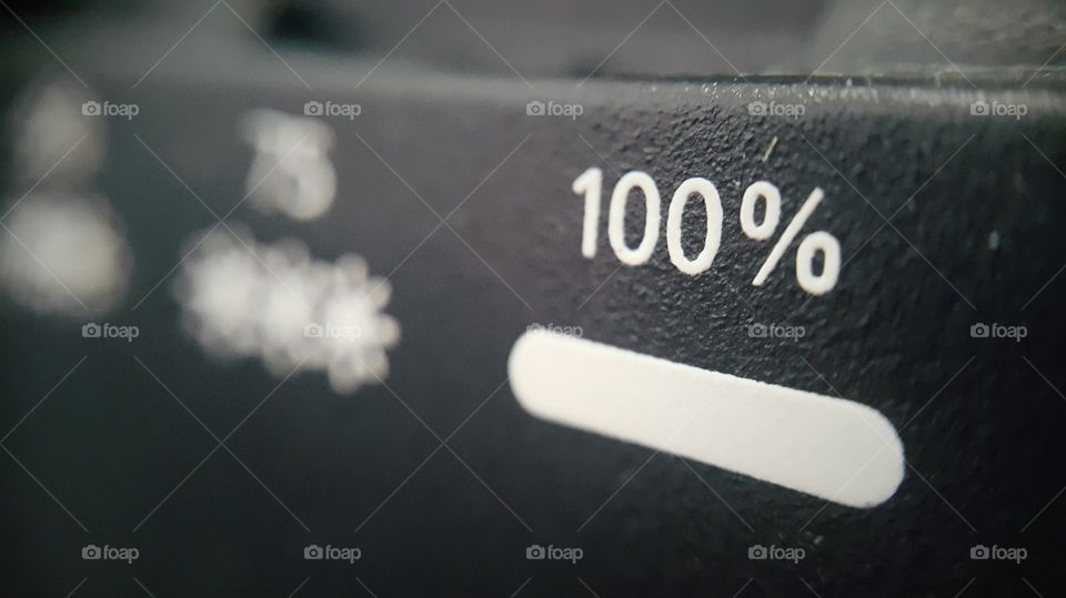Close-up of hundred percent sign on battery charger