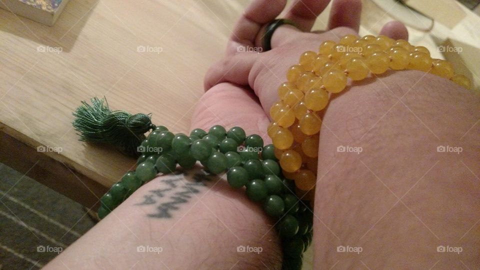 holding hands wearing malas as bracelets