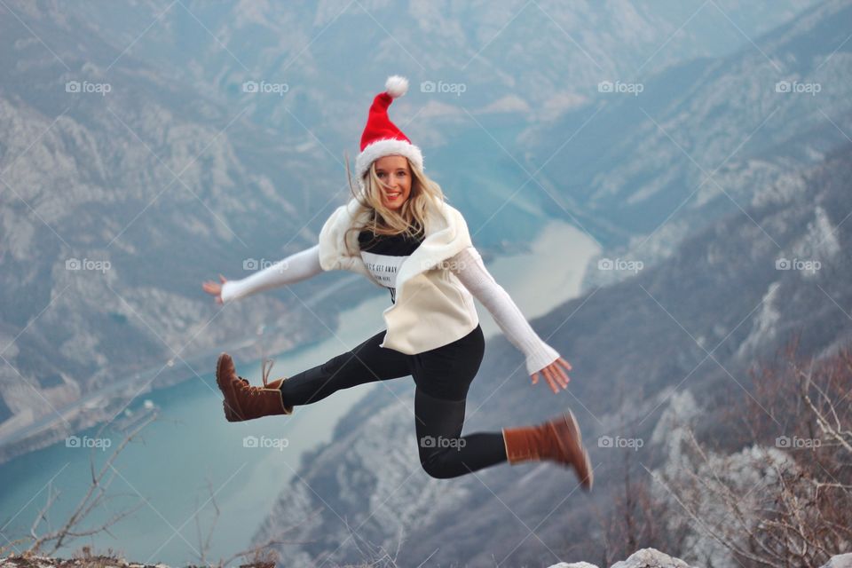 Woman jumping on mountain peak