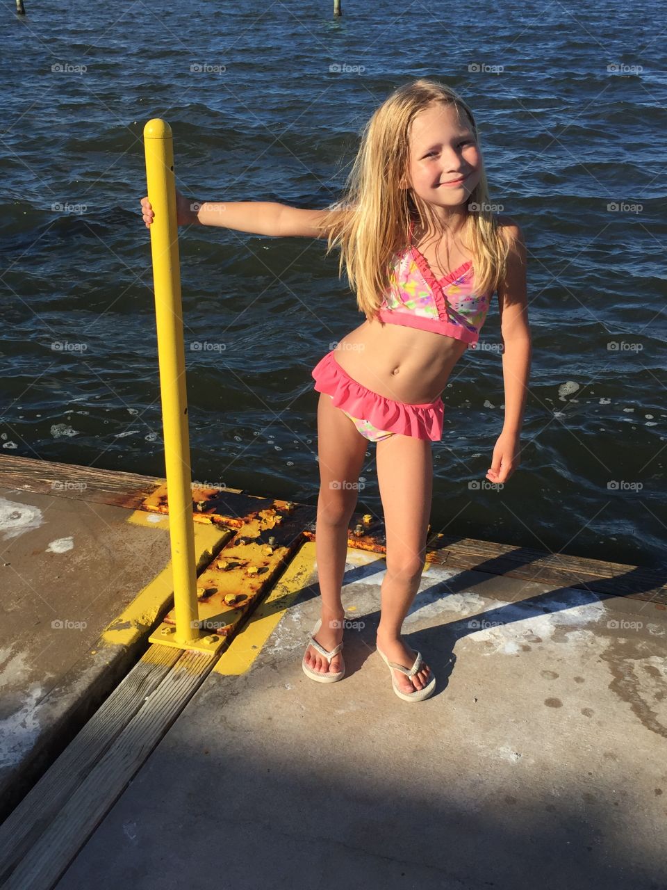 Lake type girl playing by on a dock by the ocean 