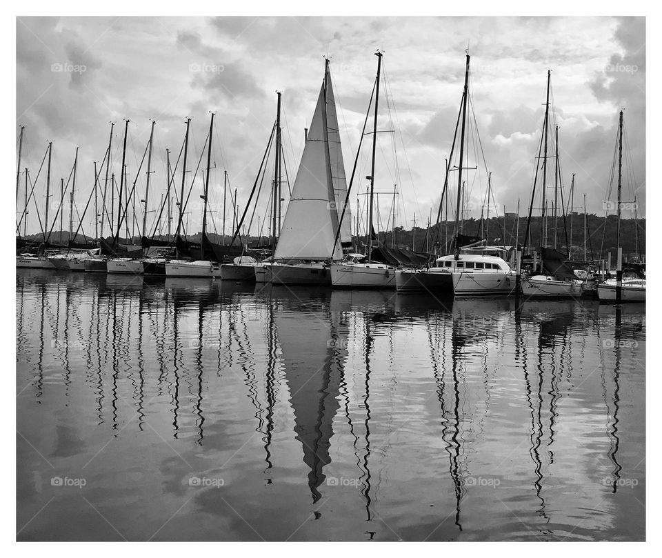 reflection in the sea of ​​sailboats in a marina