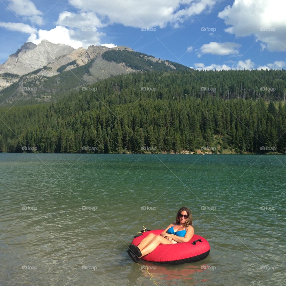 Woman sitting in inflatable boat on lake