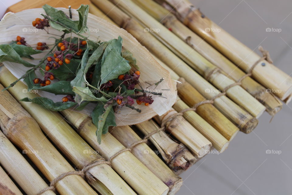 bamboo table with red species of berries and leaves