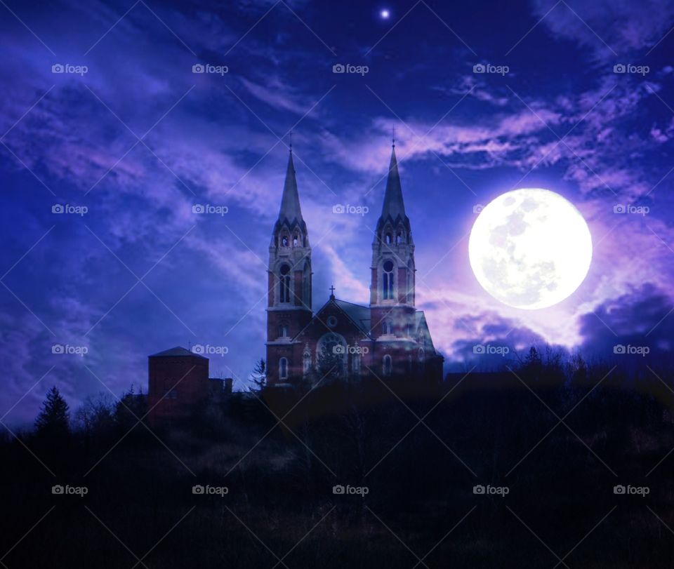 historic holy hill church hubertus Wisconsin at night with full moon and dramatic clouds