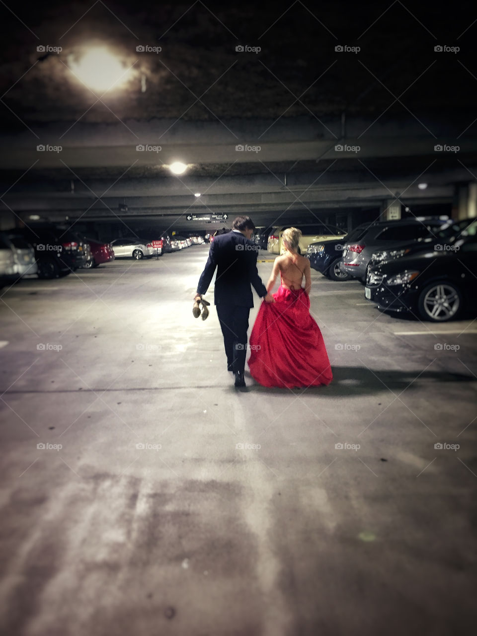 Prom couple going back to their car in a parking garage