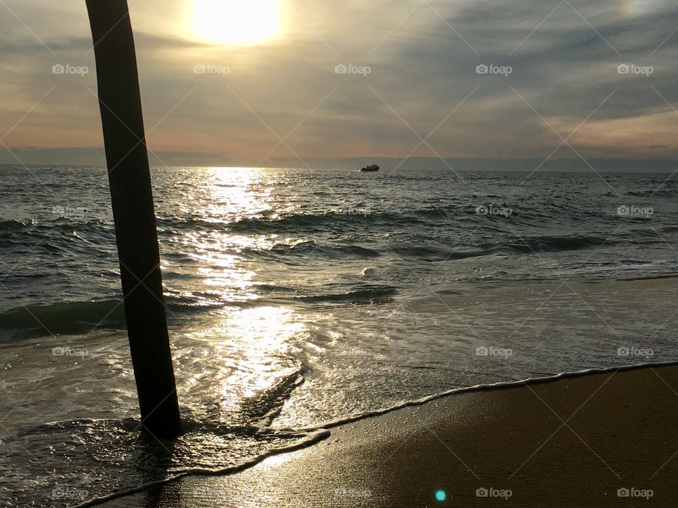 Dawn sun rise at the Pier with ship on the horizon 