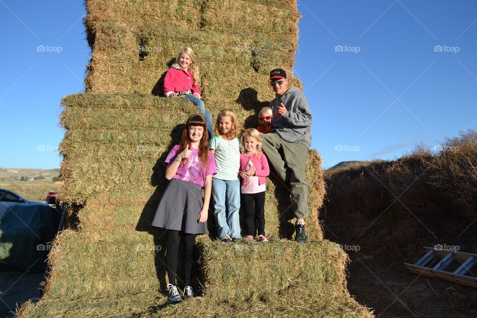 Group of young men and women standing on hay stack