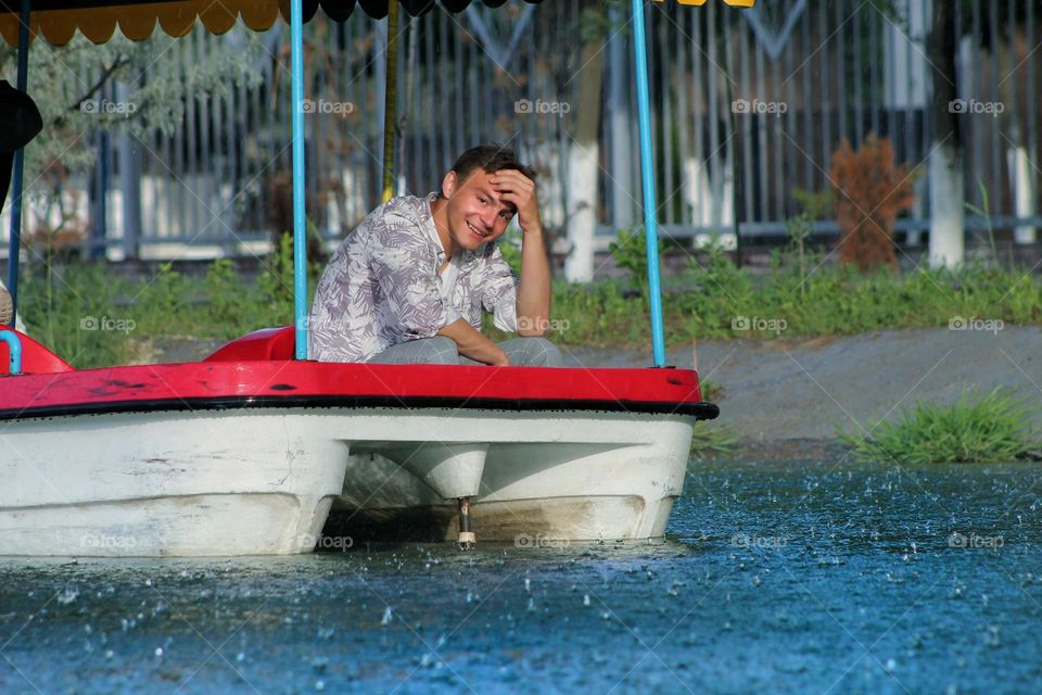 guy on a catamaran in the city pond in the park