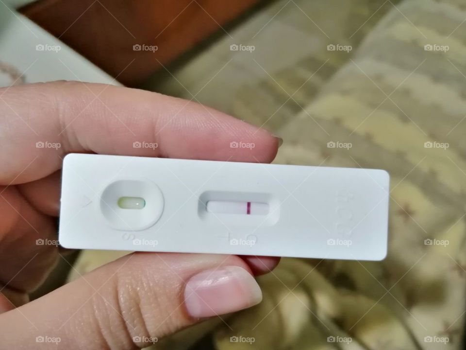 The girl holds a pregnancy test in her hand, the result is negative