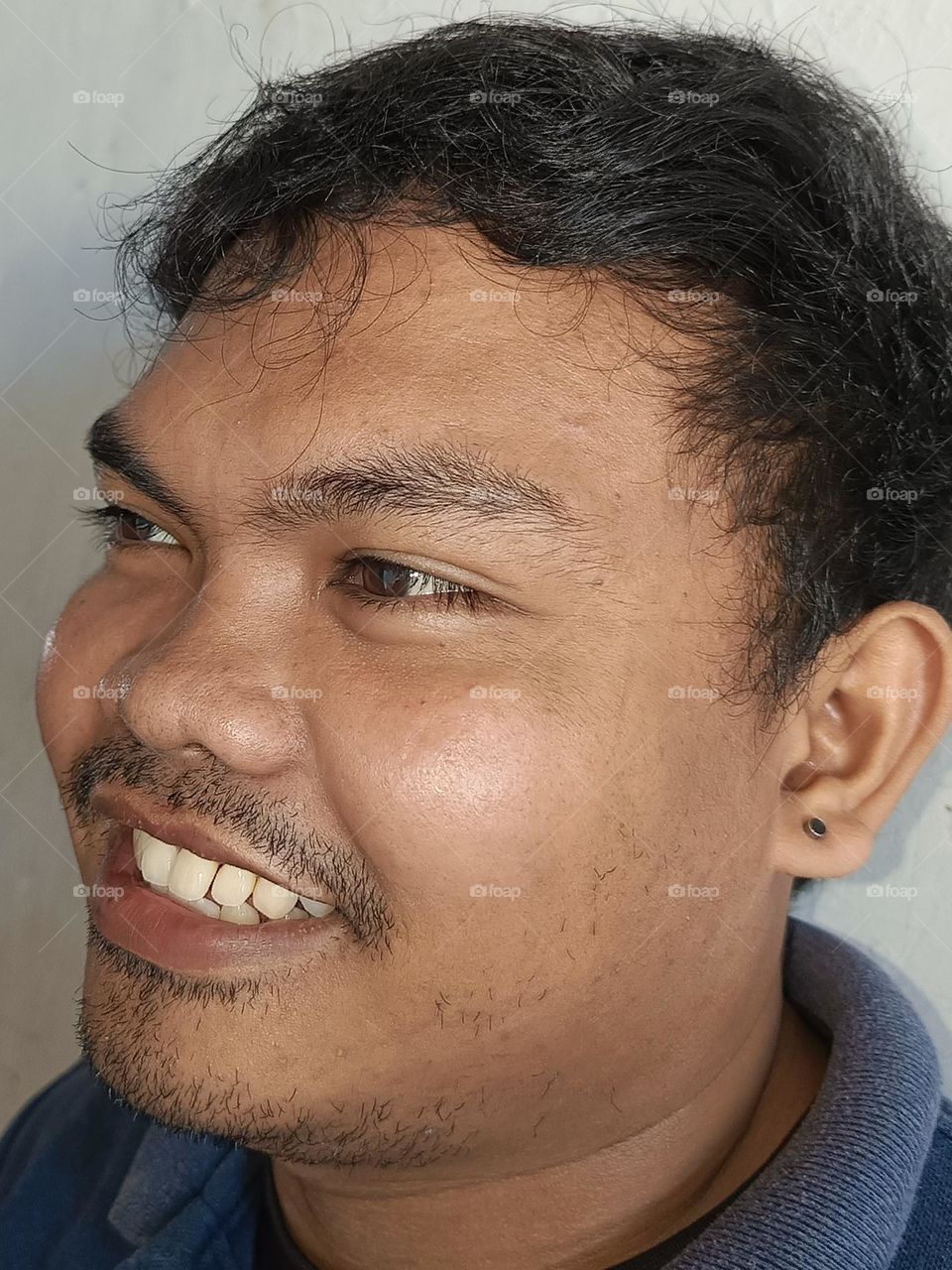 "Lost in a moment of thought, a smile forms, capturing the warmth of a quiet confidence."