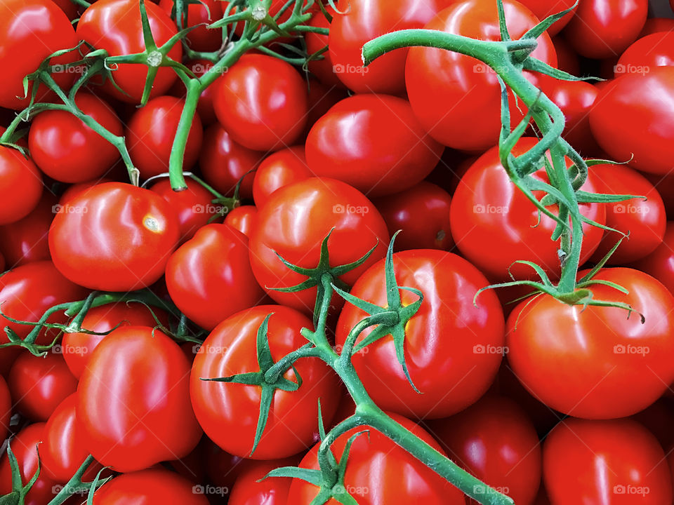 Many red cherry tomatoes with green peduncles