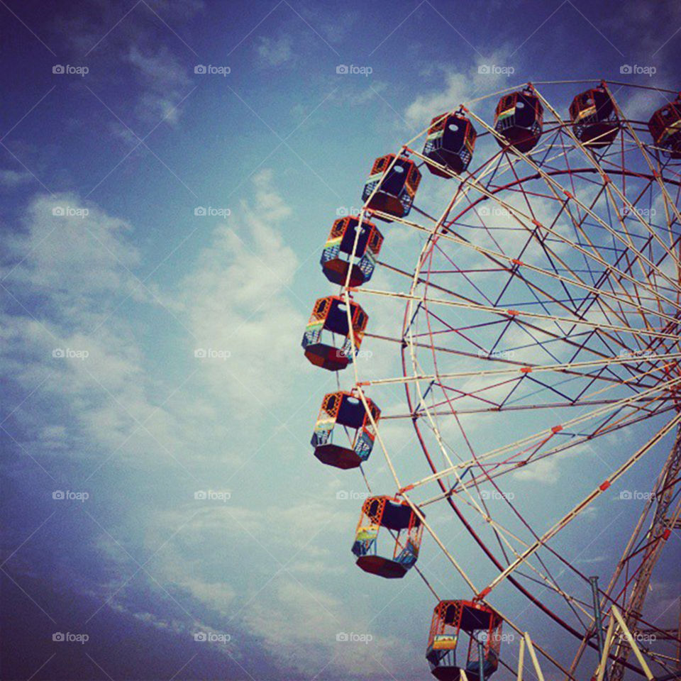 Low angle view of ferries wheel against cloudy sky