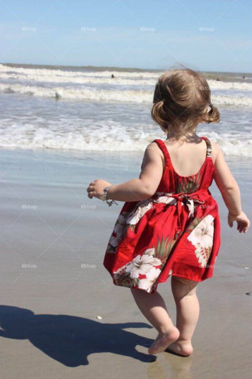 Little girl plays on the beach