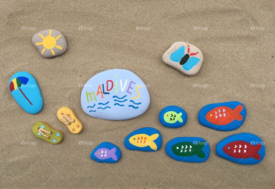 Maldives, souvenir on painted stones  over the sand 