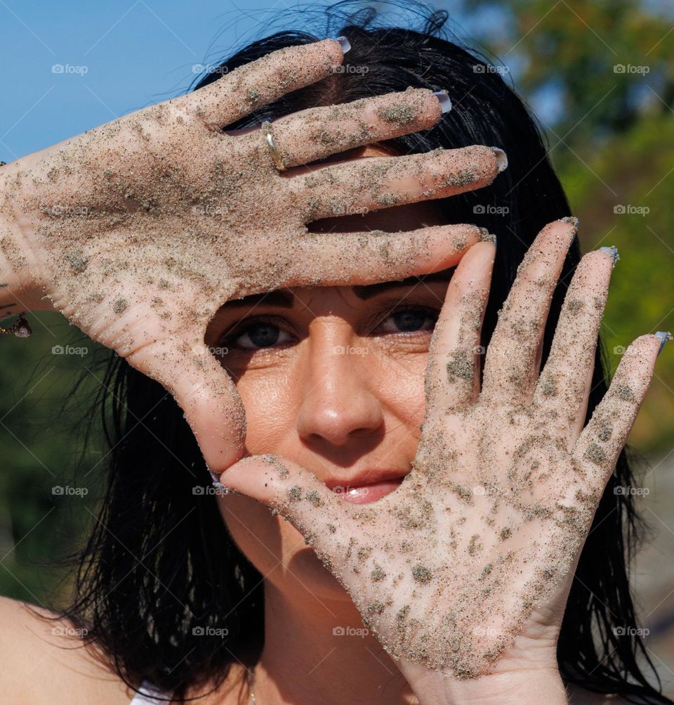 Beautiful lady makes art in the sand .
Using the hands at the beach .
portrait of a beautiful woman