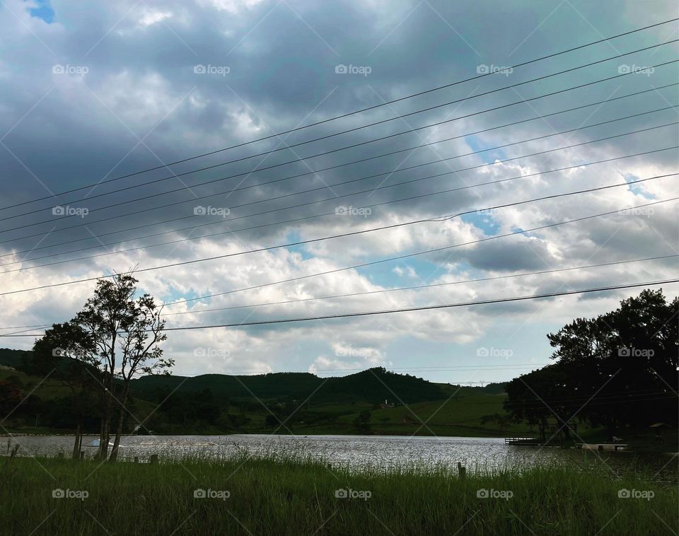 On the edge of the Biriçá Dam, dark clouds are approaching.  Is rain coming?  It could be, with the heat it's been doing... / À beira da Represa do Biriçá, nuvens escuras se aproximam. Vem vindo chuva? Pudera, com o calor que está fazendo…