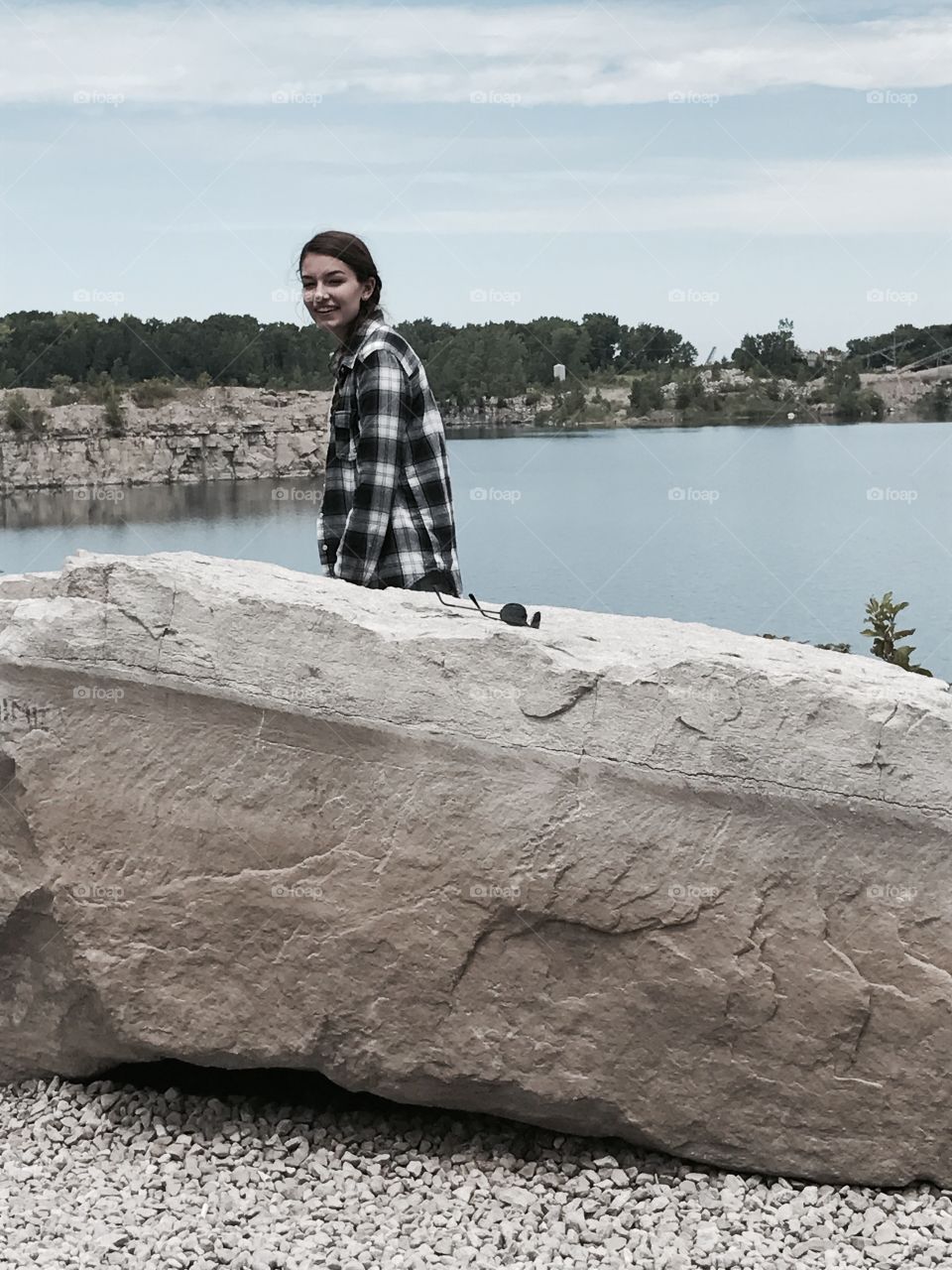 Young woman standing near rock